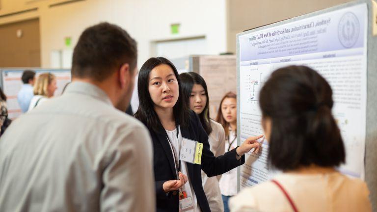 a student presents a poster at PURCC